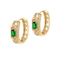A pair of gold hoop earrings with a central brilliant green stone, surrounded by smaller clear stones.