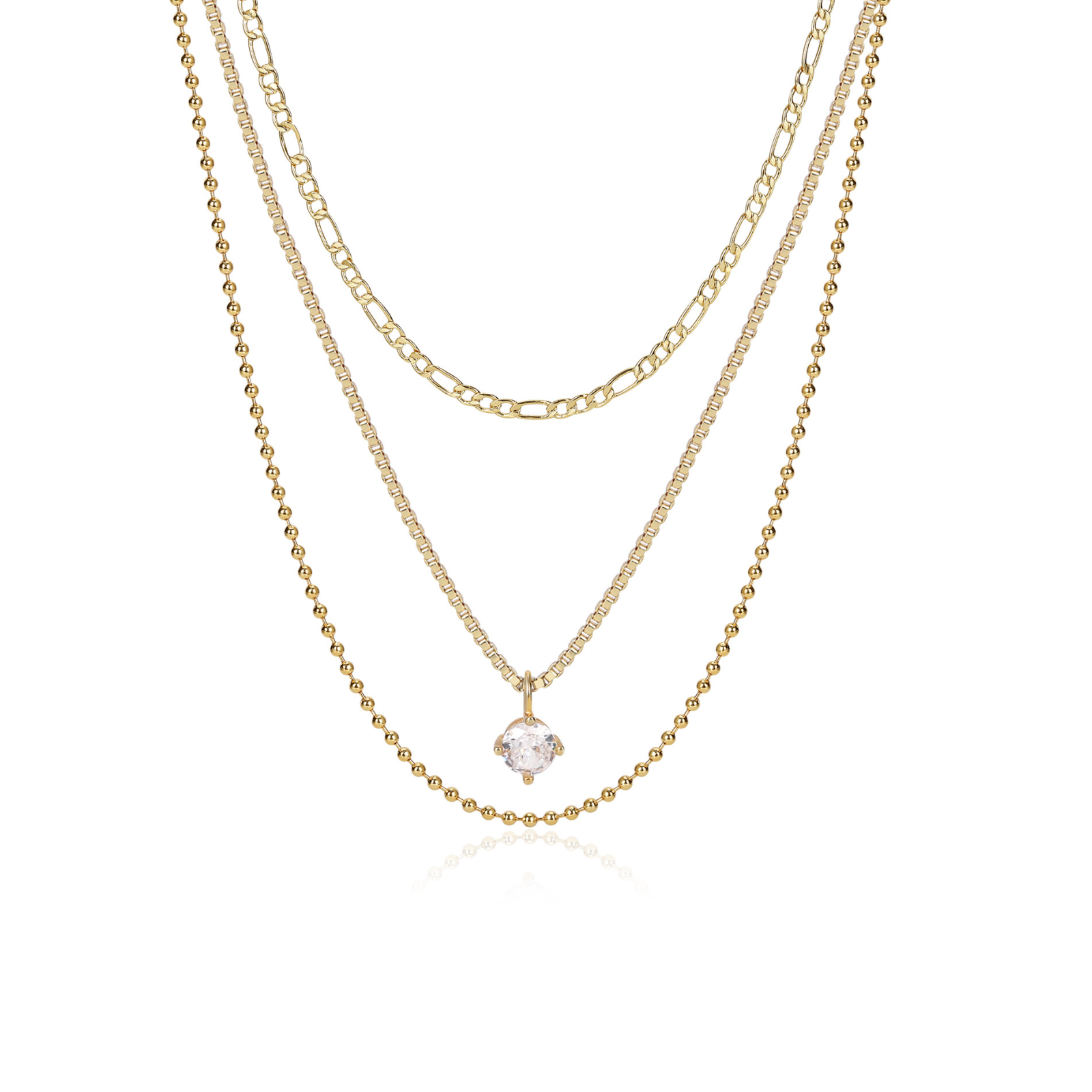 A layered gold necklace set featuring three distinct chain styles: a delicate cable chain, a Figaro link chain, and a tennis chain with a small clear gemstone pendant, displayed on a clean white background.