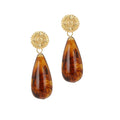 A pair of brown earrings with a gold sunburst design and teardrop resin pendants.