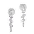 A pair of white gold earrings with intricate designs and drop features, showcasing multiple gemstones.